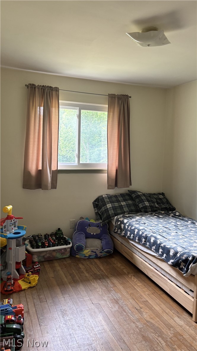 11784 Chamberlain Road Mantua, OH 44255 - Photo 18 of 50 Bright bedroom with wood-finish flooring, large window with natural light, and ceiling-mounted ventilation