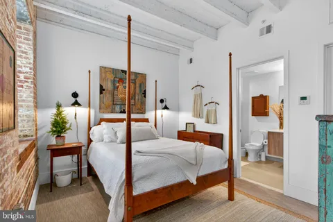 a bedroom with a bed and wooden floor