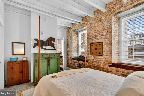 a bedroom with a bed dresser and a flat tv screen