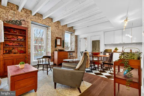 a living room with furniture kitchen view and a large window