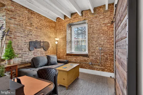 a living room with couches a fireplace and a large window