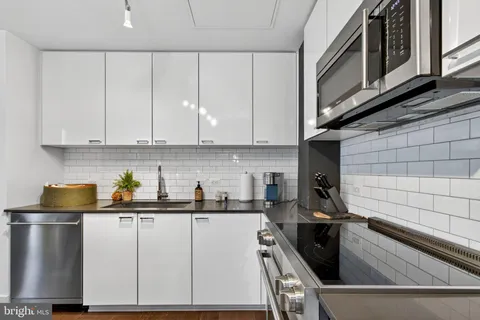 a kitchen with a white cabinets and black appliances