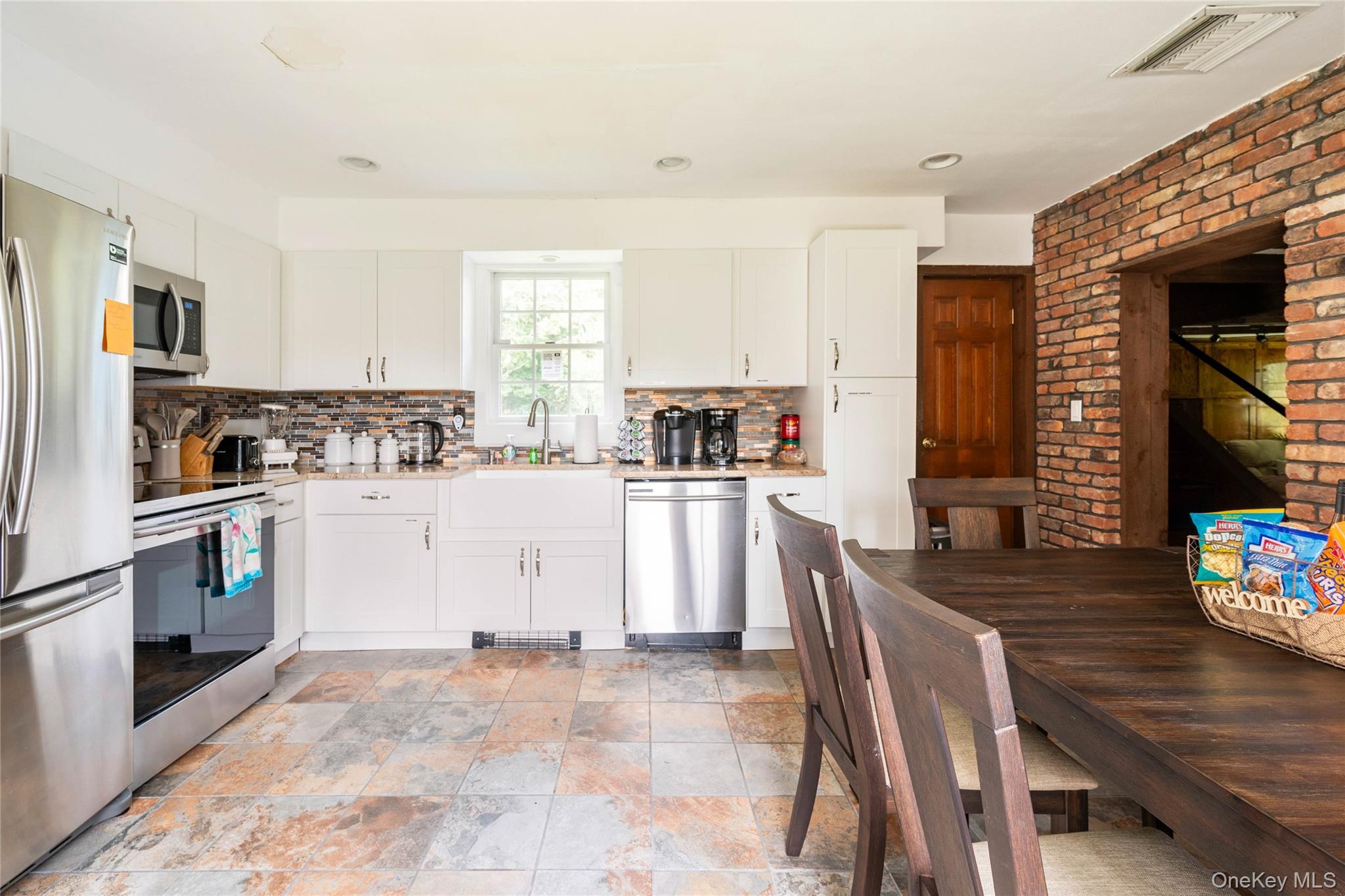 670 Creamery Road Mongaup Valley, NY 12762 - Photo 28 of 47 a kitchen with granite countertop a refrigerator a stove top oven a sink dishwasher and white cabinets with wooden floor