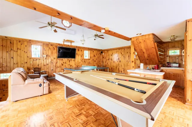 a living room with stainless steel appliances kitchen island granite countertop furniture and a flat screen tv