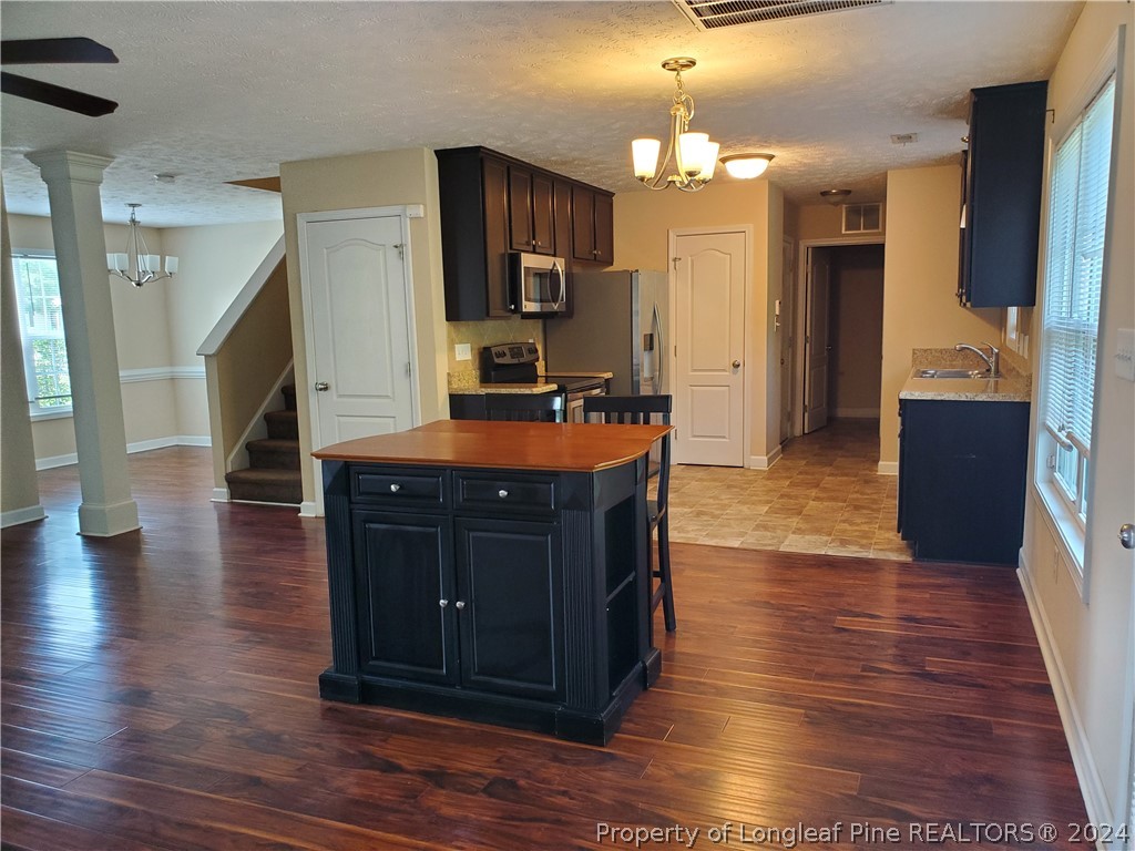 2713 Rockfish Road Raeford, NC 28376 - Photo 7 of 29 a large kitchen with stainless steel appliances granite countertop a stove and wooden floor