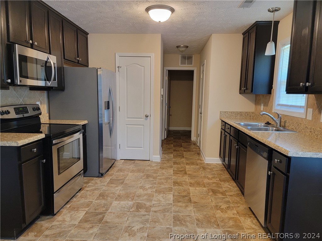 2713 Rockfish Road Raeford, NC 28376 - Photo 9 of 29 a kitchen with stainless steel appliances a sink stove and refrigerator