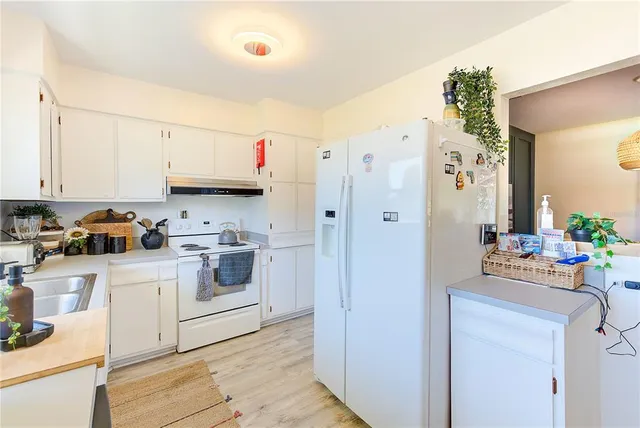 a kitchen with white cabinets and white appliances