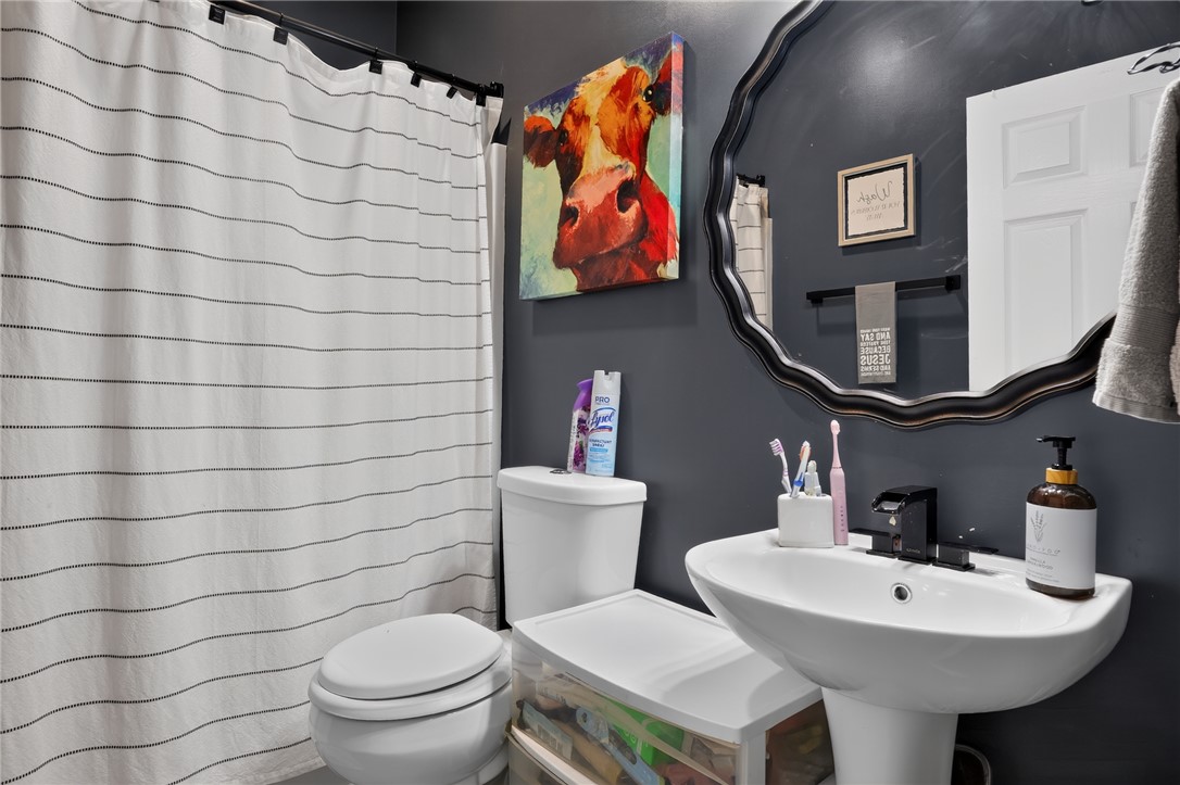 144 Elliott Circle Anderson, SC 29621 - Photo 28 of 30 A chic bathroom offers a clean pedestal sink and a contemporary, scalloped mirror.