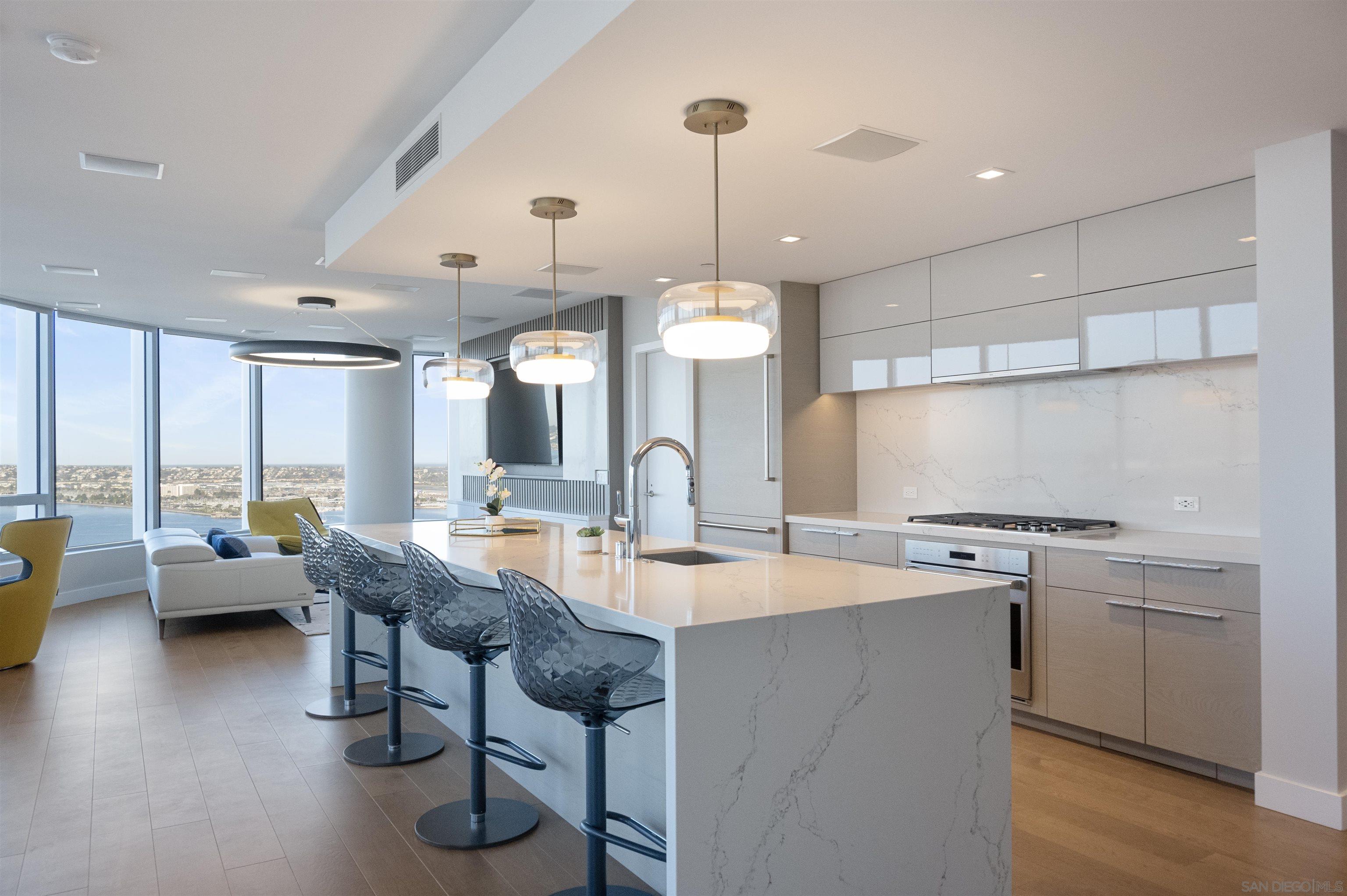888 E Street, Unit 3602 San Diego, CA 92101 - Photo 13 of 51 a open kitchen with stainless steel appliances granite countertop a stove and a view of living room
