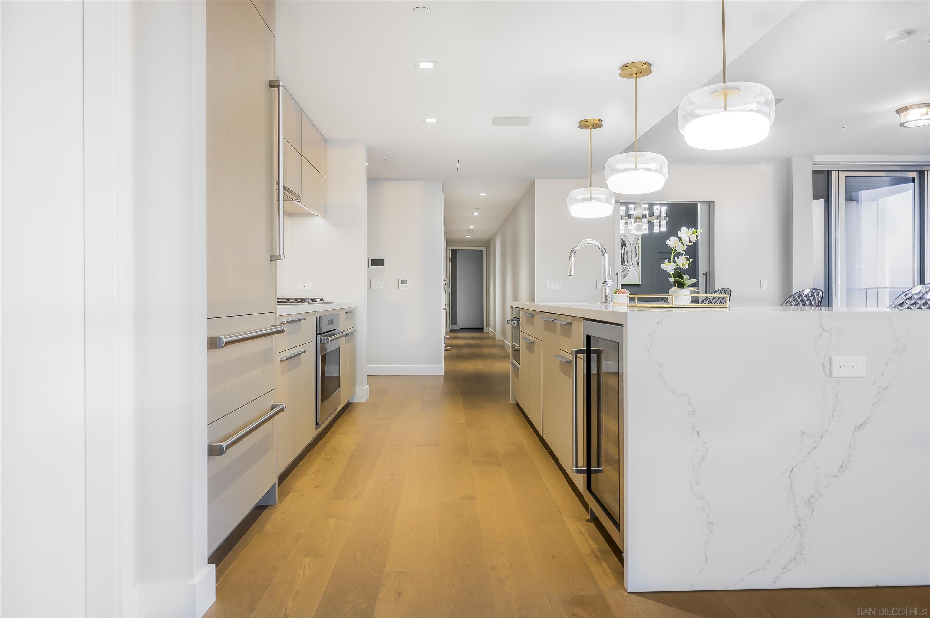 888 E Street, Unit 3602 San Diego, CA 92101 - Photo 15 of 51 a large white kitchen with a stove a sink a refrigerator and a refrigerator