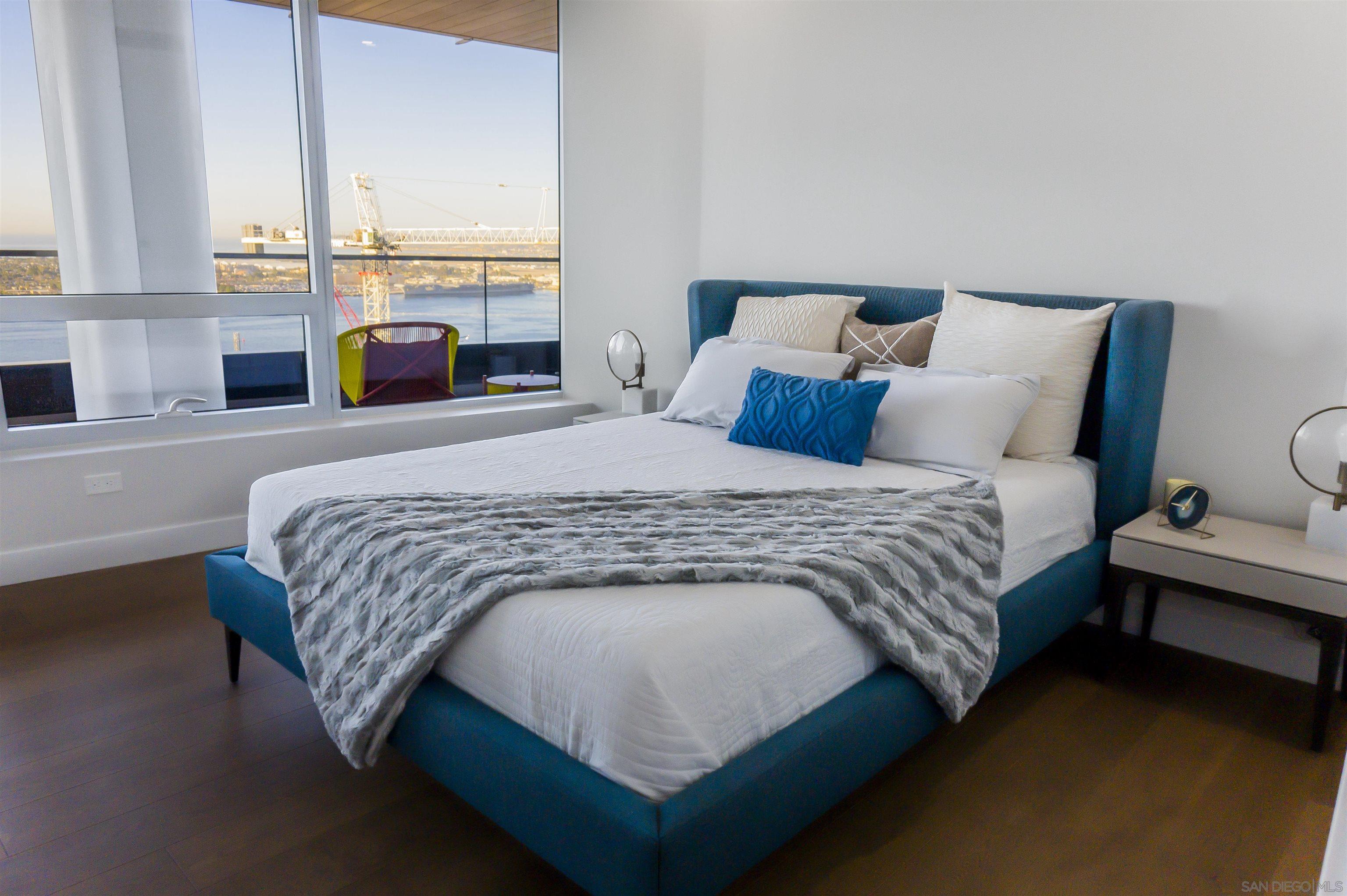 888 E Street, Unit 3602 San Diego, CA 92101 - Photo 25 of 51 a large bed sitting in a bedroom next to a window with lamp