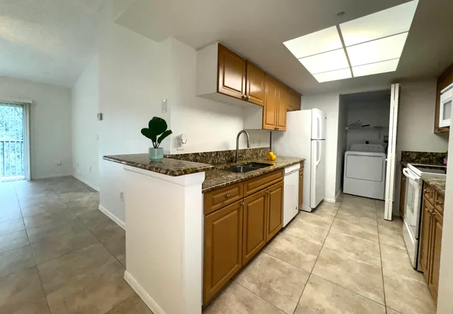 a kitchen with stainless steel appliances granite countertop a stove a refrigerator and a sink