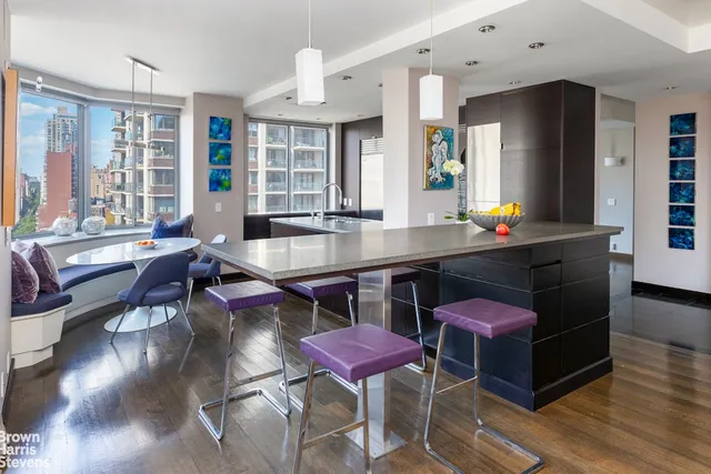 a living room with furniture a wooden floor and a large window