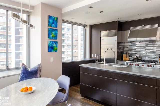 a dining room with furniture and a large window