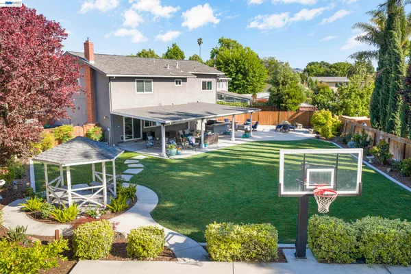 a view of a house with a yard patio and a table and chairs