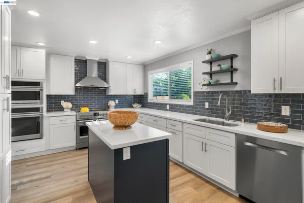 a kitchen with stainless steel appliances granite countertop a sink stove and refrigerator