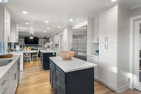 a kitchen with stainless steel appliances kitchen island granite countertop a sink and a refrigerator