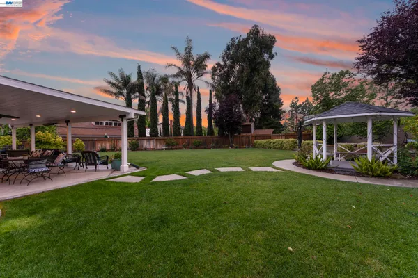a view of a house with backyard and sitting area