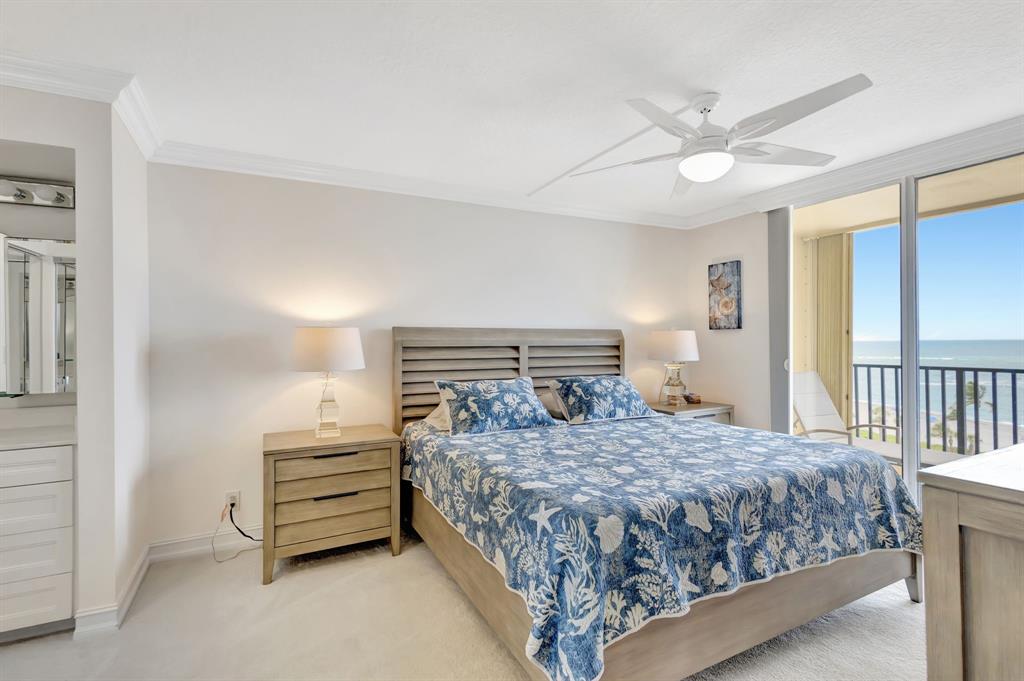 300 Ocean Trail Way, Unit 907 Jupiter, FL 33477 - Photo 15 of 42 a bedroom with a bed and a chandelier