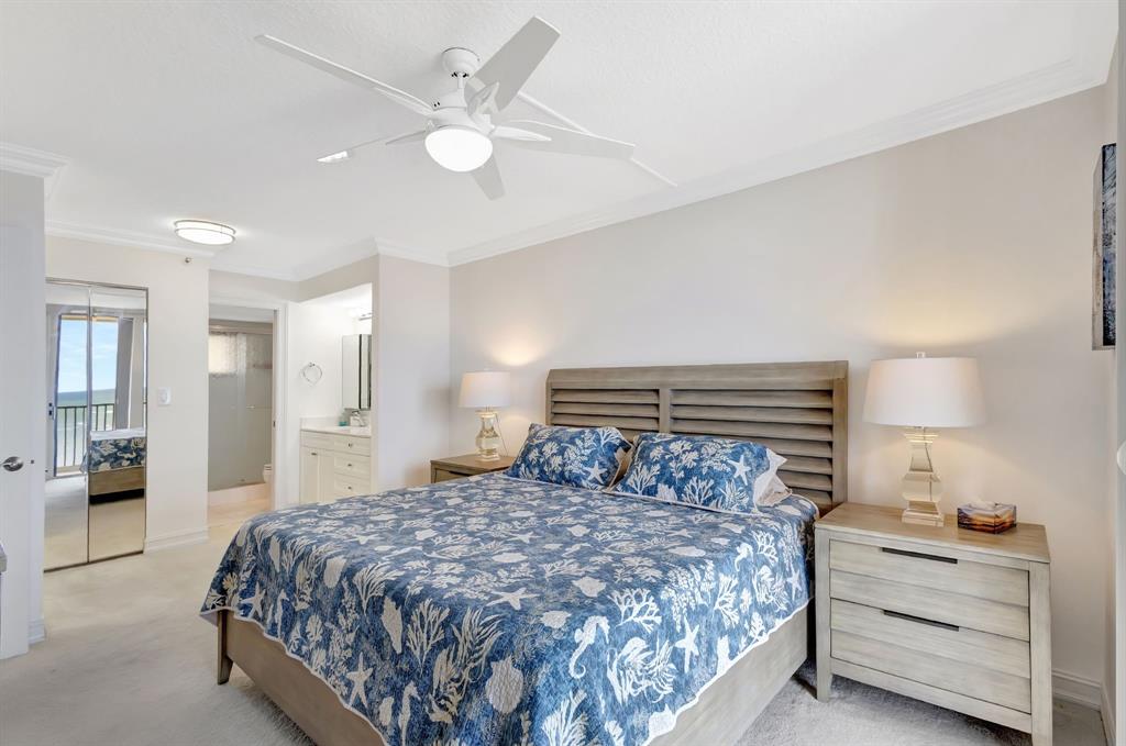 300 Ocean Trail Way, Unit 907 Jupiter, FL 33477 - Photo 16 of 42 a bedroom with a bed and a chandelier