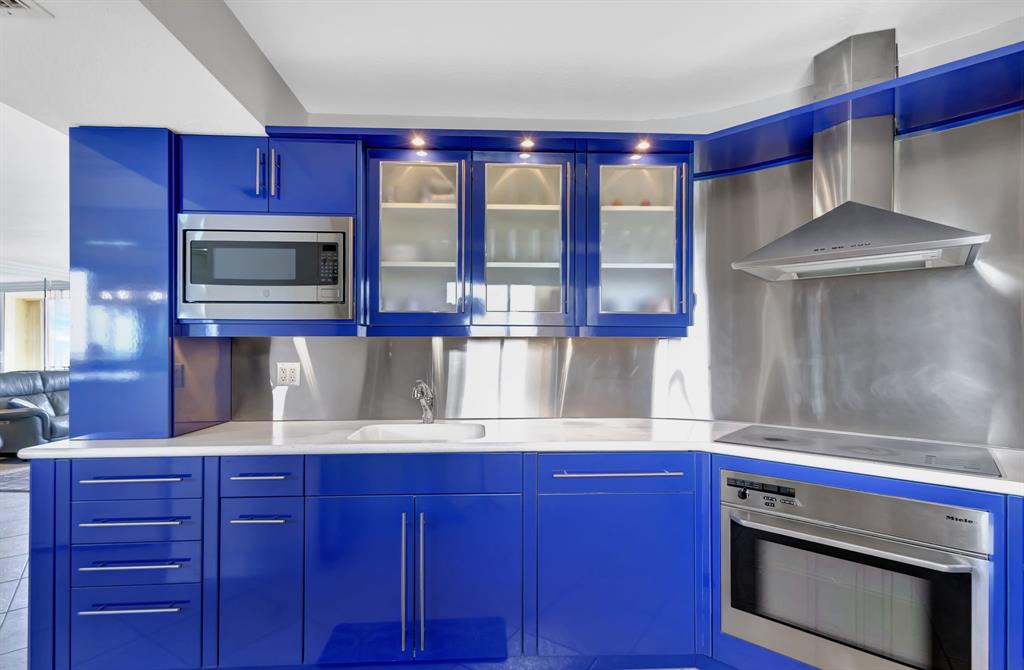 300 Ocean Trail Way, Unit 907 Jupiter, FL 33477 - Photo 10 of 42 a kitchen with wooden cabinets and stainless steel appliances