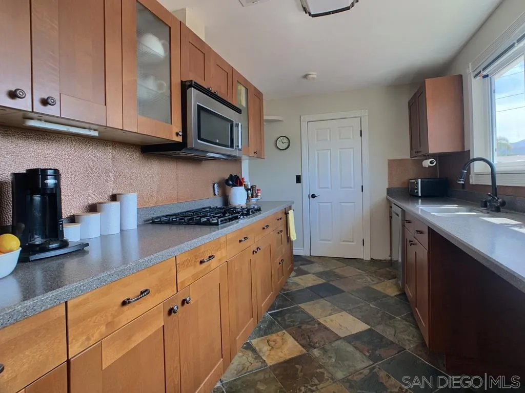 14416 Springvale Street Poway, CA 92064 - Photo 5 of 18 a kitchen with stainless steel appliances granite countertop a sink stove and cabinets