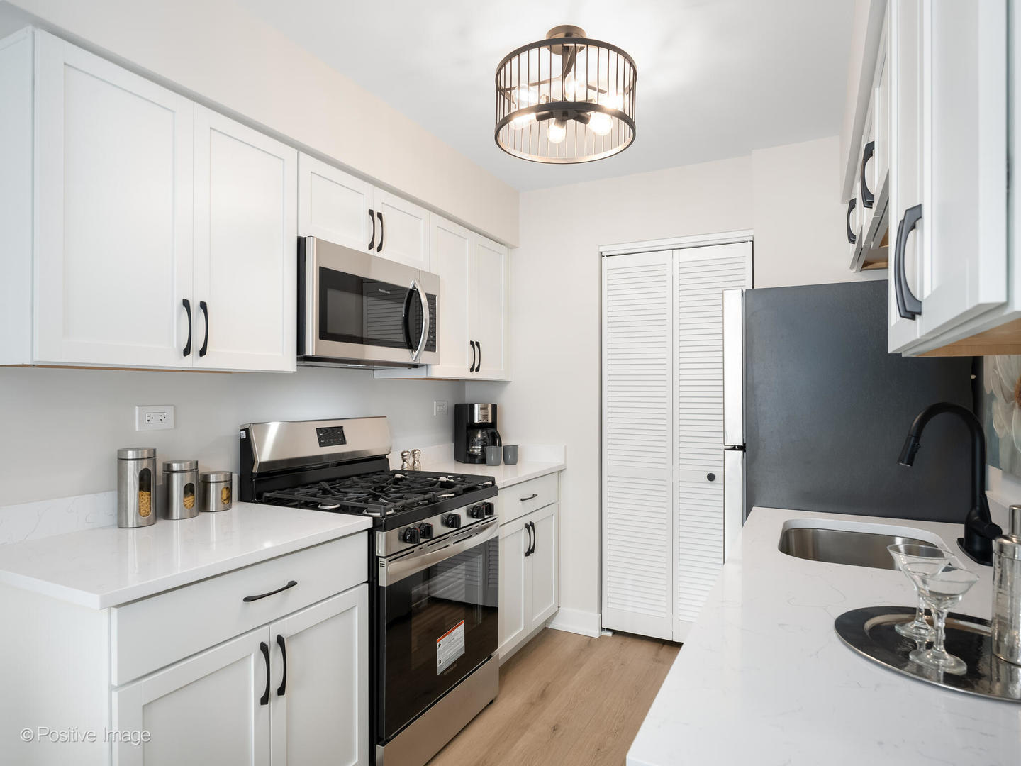 823 Cambridge Place, Unit 823 Wheeling, IL 60090 - Photo 8 of 16 a kitchen with stainless steel appliances a white cabinet and a stove top oven