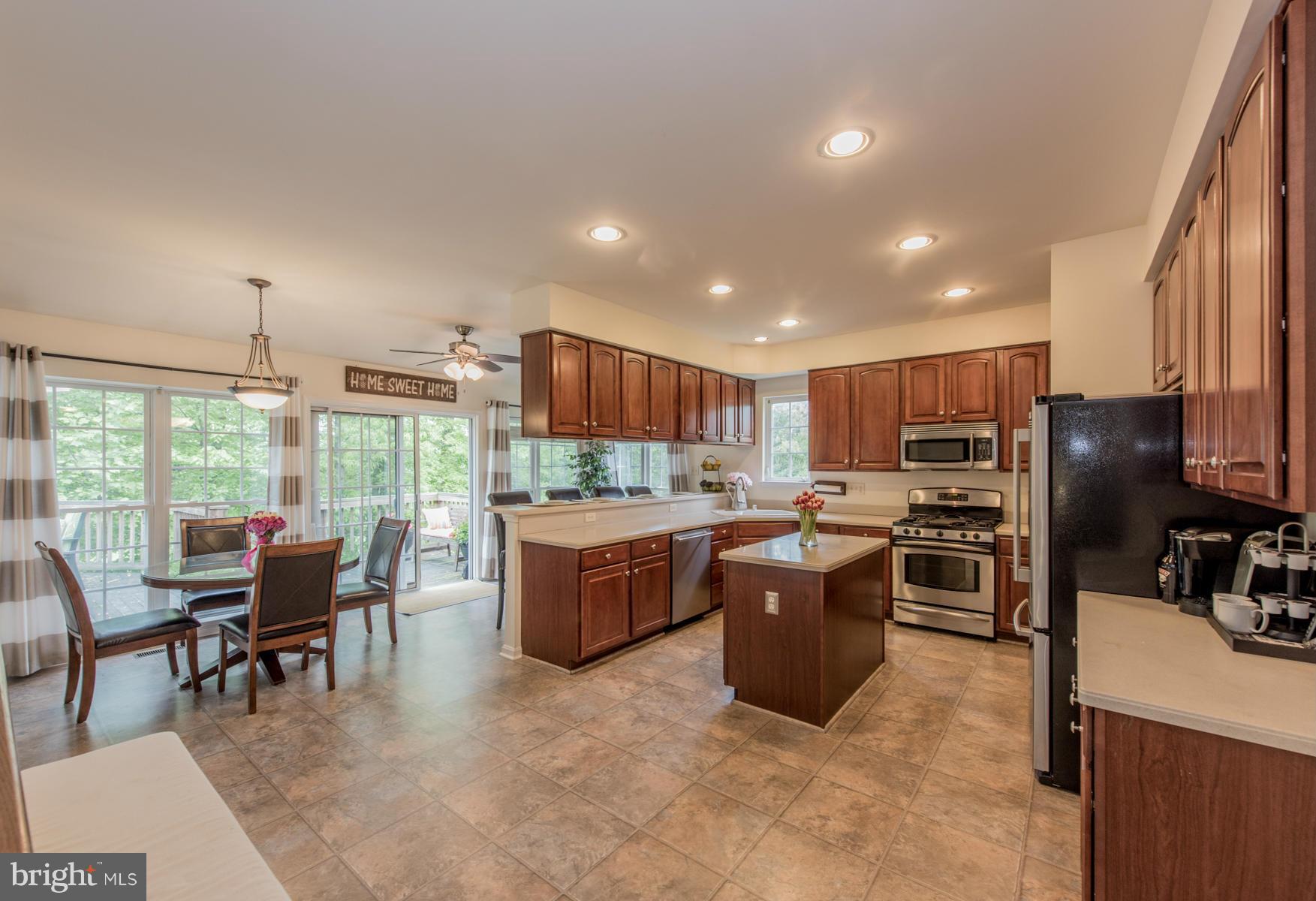 6013 Sandy Ridge Elkridge, MD 21075 - Photo 3 of 30 a kitchen with a refrigerator a stove dining table and chairs