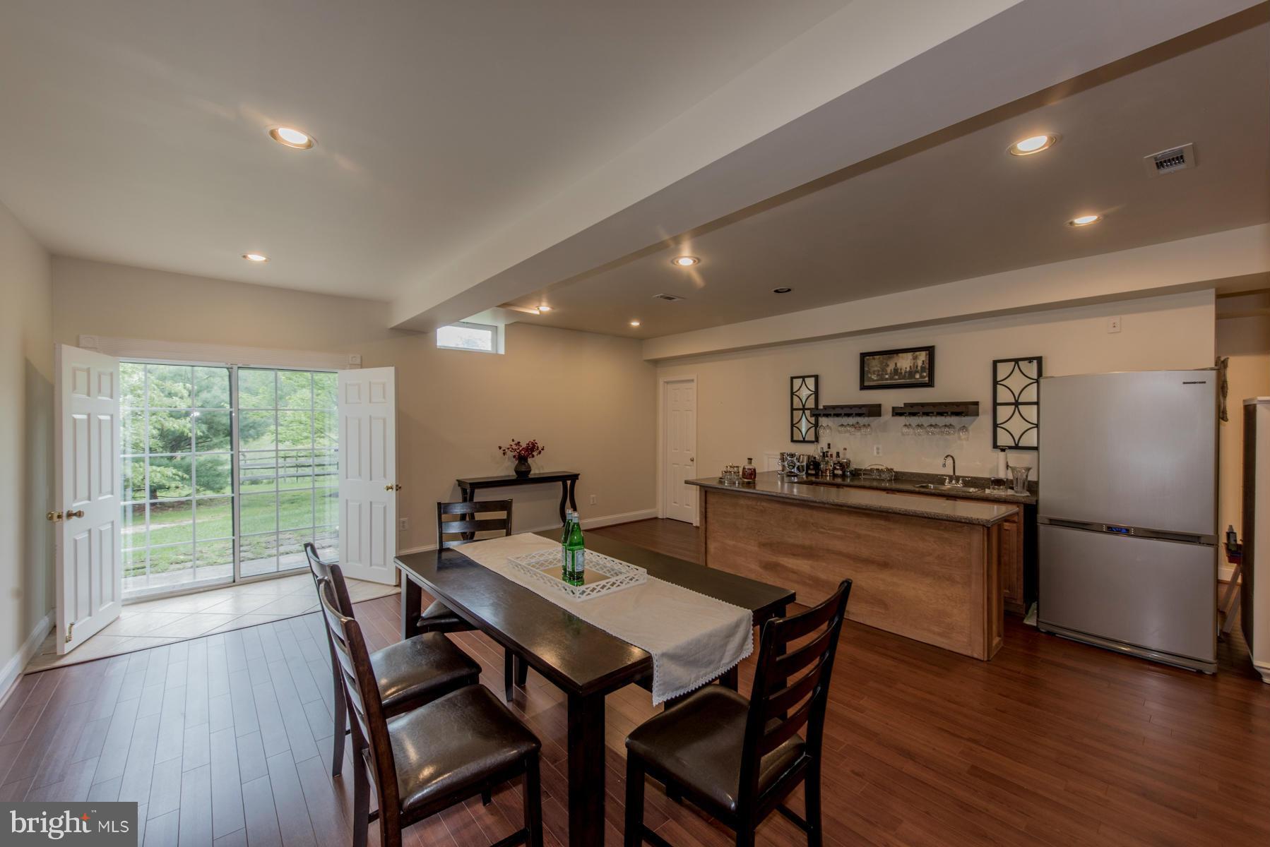 6013 Sandy Ridge Elkridge, MD 21075 - Photo 26 of 30 a kitchen with stainless steel appliances granite countertop a stove a refrigerator a kitchen island a table and chairs