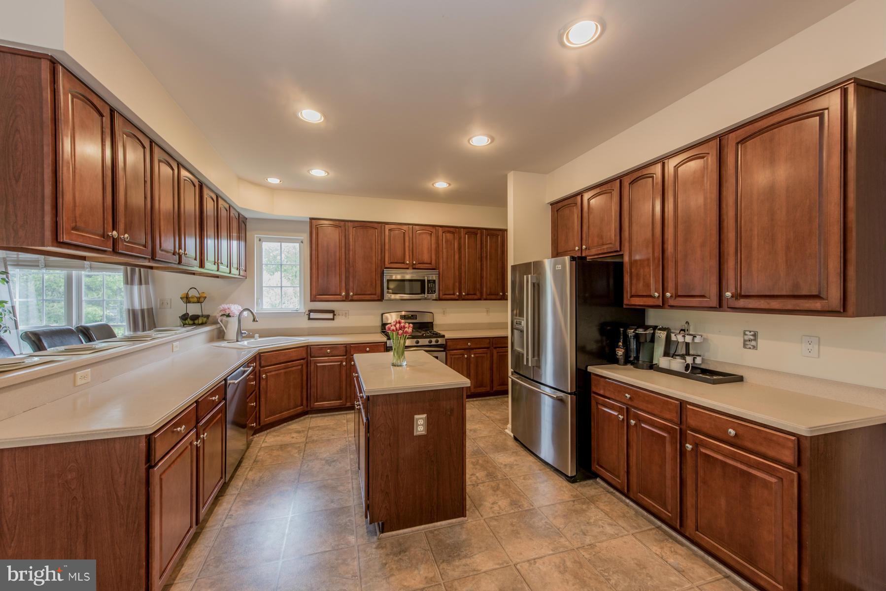 6013 Sandy Ridge Elkridge, MD 21075 - Photo 10 of 30 a kitchen with stainless steel appliances granite countertop wooden cabinets a sink dishwasher a stove and a refrigerator