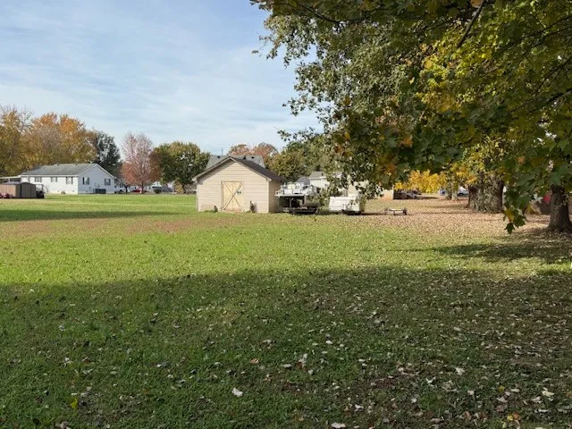 a view of a field with trees in the background