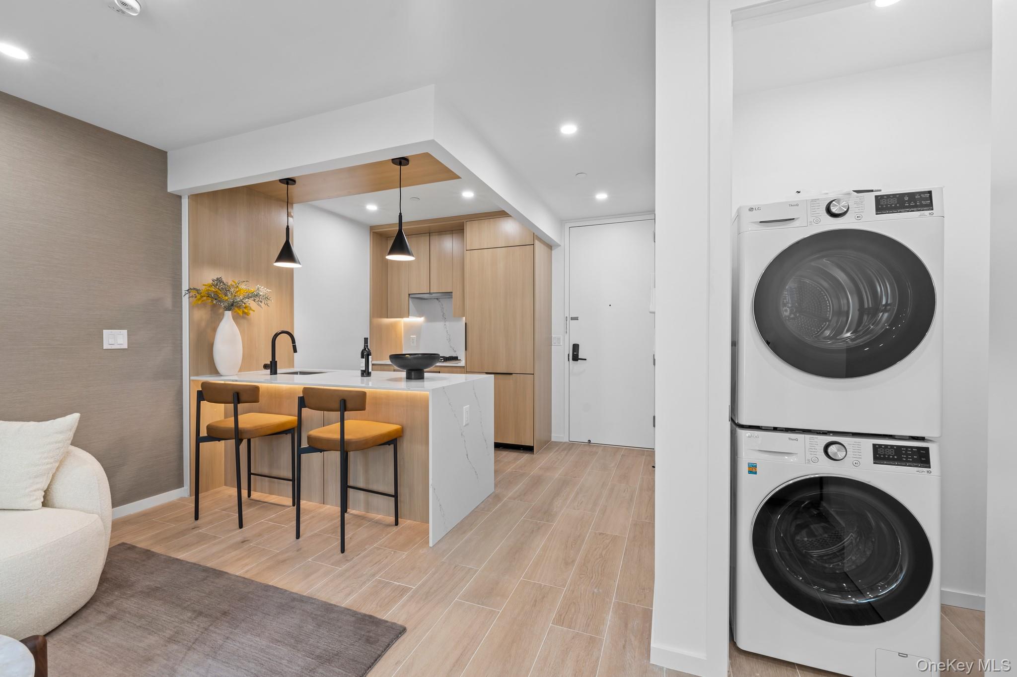 366 Harman Street, Unit 2R Brooklyn, NY 11237 - Photo 18 of 31 Laundry area featuring stacked washer / drying machine, wood finish floors, and recessed lighting