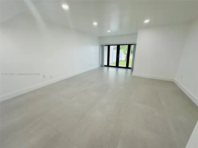 a large white kitchen with a sink a microwave and white cabinets