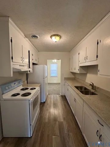 a kitchen with granite countertop white cabinets and a sink