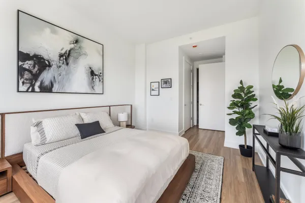 a bedroom with a large bed and a potted plant