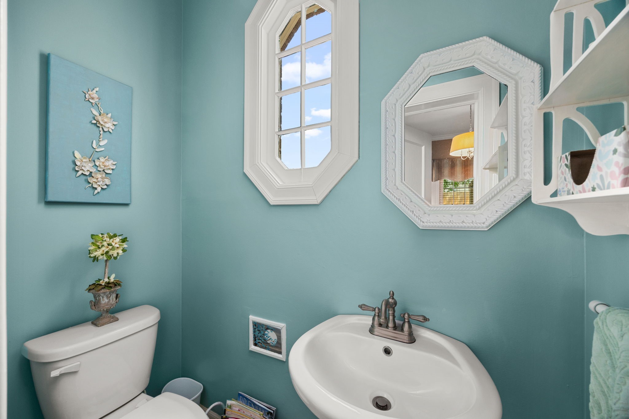 801 West Main Street Brenham, TX 77833 - Photo 8 of 50 Conveniently located just off the study, the half bathroom features charming historic touches including an octagonal window that fills the space with natural light. Soft colors and classic details create an inviting and functional addition to the office area.
