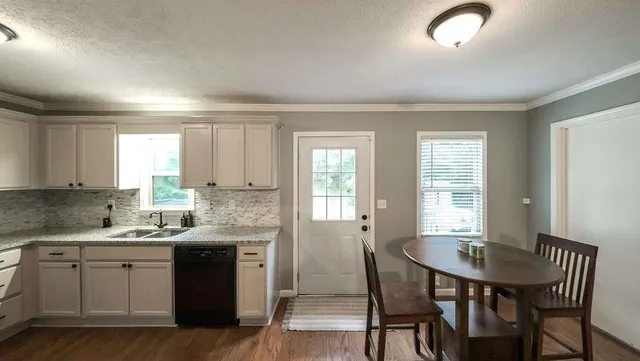 a kitchen with a table chairs sink and cabinets