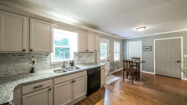 a kitchen with granite countertop sink cabinets and wooden floor