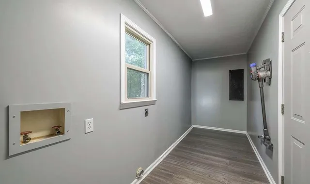 a view of hallway with window and wooden floor