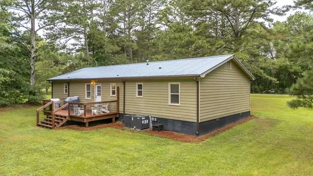 a view of a house with backyard and sitting area