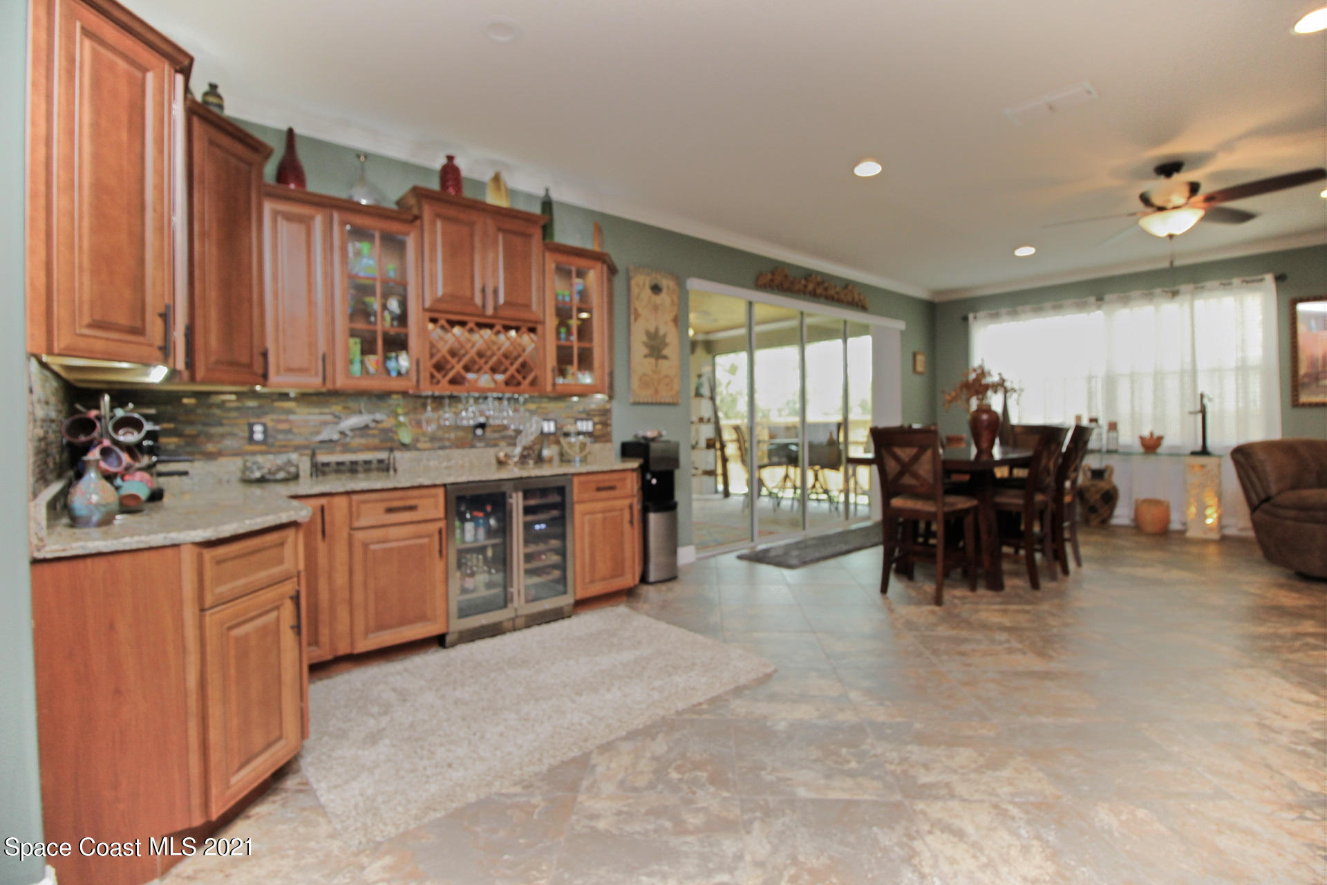 4034 Preservation Circle Melbourne, FL 32934 - Photo 13 of 25 a kitchen with stainless steel appliances kitchen island granite countertop a stove a sink a dining table and chairs