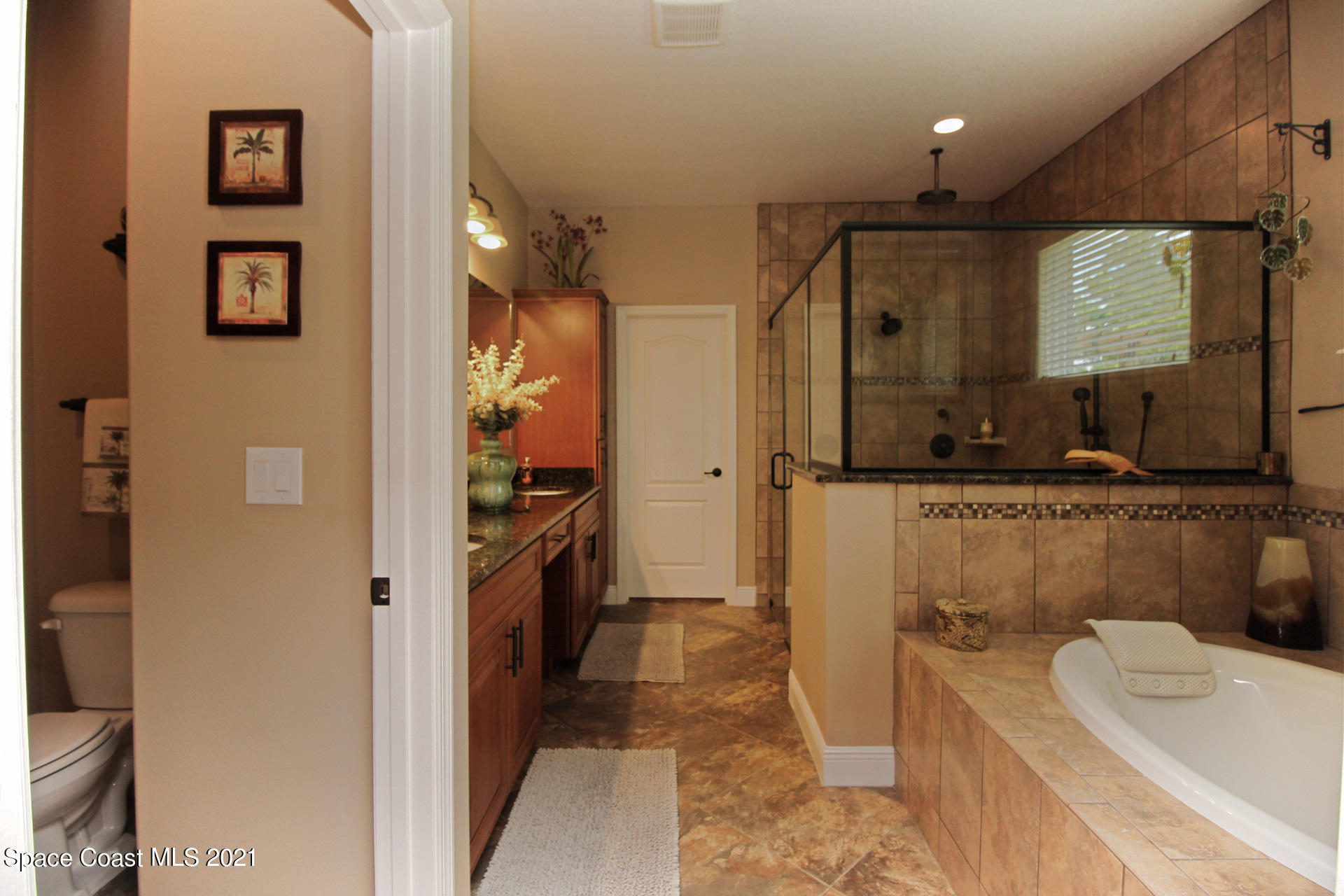 4034 Preservation Circle Melbourne, FL 32934 - Photo 15 of 25 a bathroom with a double vanity sink a toilet a mirror and shower