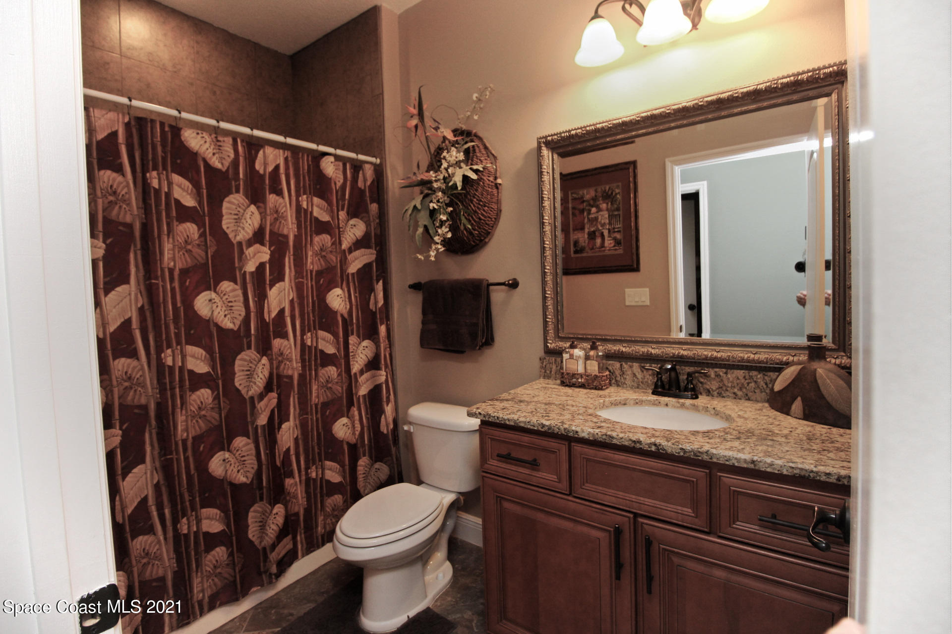 4034 Preservation Circle Melbourne, FL 32934 - Photo 17 of 25 a bathroom with a granite countertop sink toilet and mirror