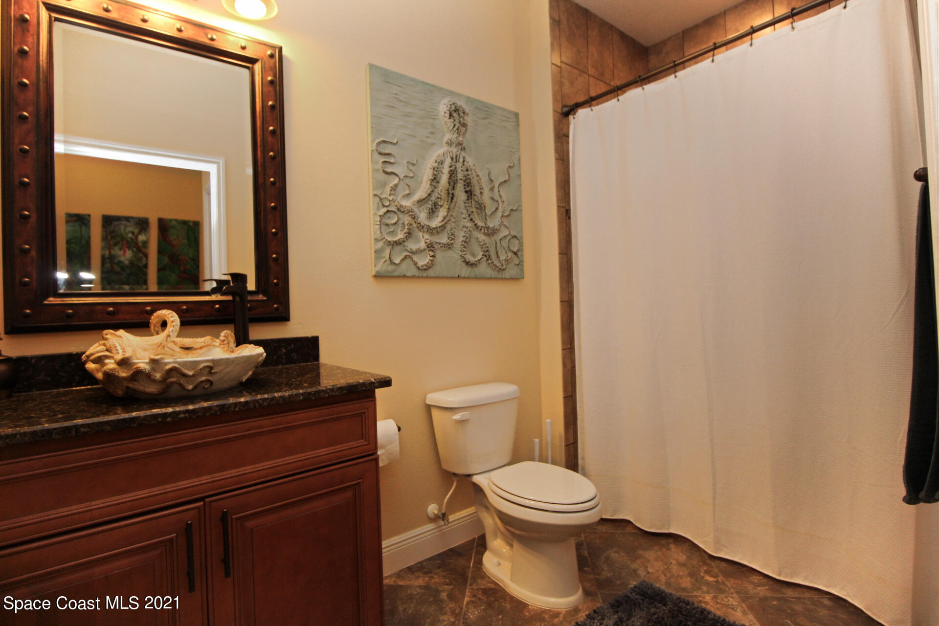 4034 Preservation Circle Melbourne, FL 32934 - Photo 21 of 25 a bathroom with a toilet a sink and a mirror