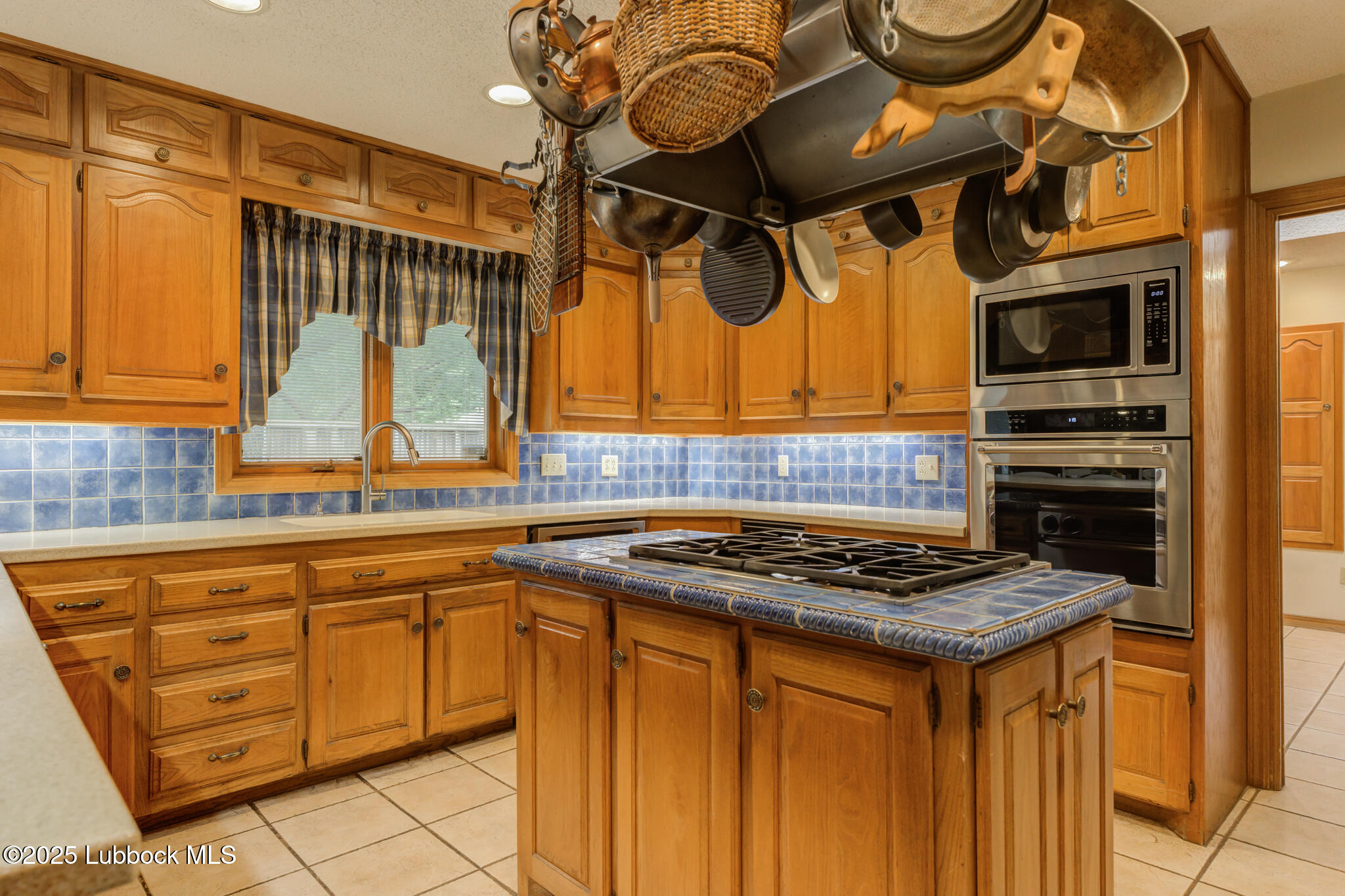 4206 89th Street Lubbock, TX 79423 - Photo 12 of 50 a kitchen with stainless steel appliances granite countertop a stove a sink and a microwave