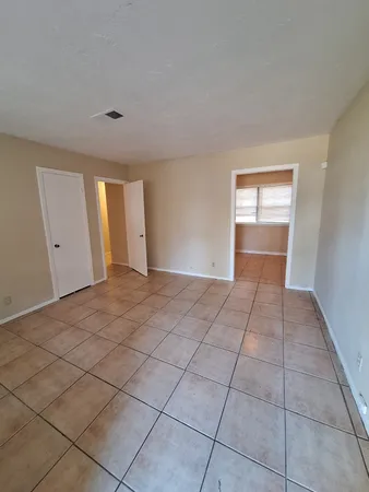 a view of an empty room and window and chandelier