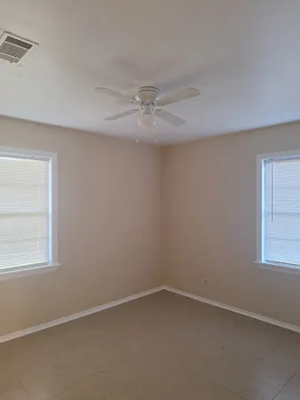 an empty room with a window and a fan
