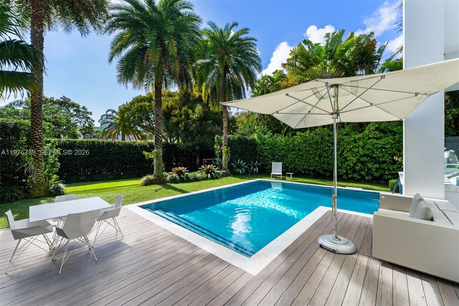 741 Harbor Drive Key Biscayne, FL 33149 - Photo 33 of 36 a view of a swimming pool with a lounge chair and a garden
