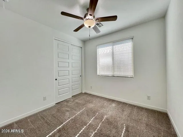 an empty room with windows and fan
