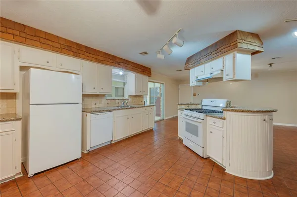 a kitchen with white cabinets and white appliances